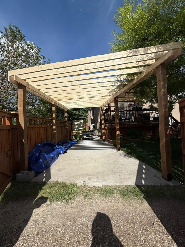 Custom wood pergola and fence built in a Calgary backyard